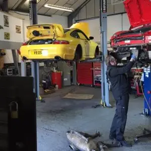Porsche servicing experts at work on two Porsche models